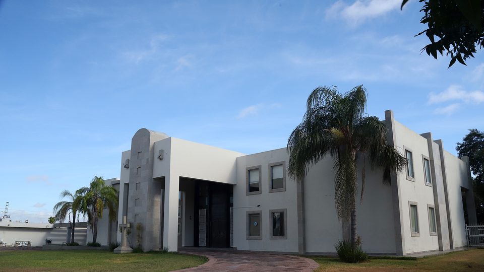 Campus del Instituto Newman del Oratorio en Reynosa, Tamaulipas — entrada principal con cruz y palmeras